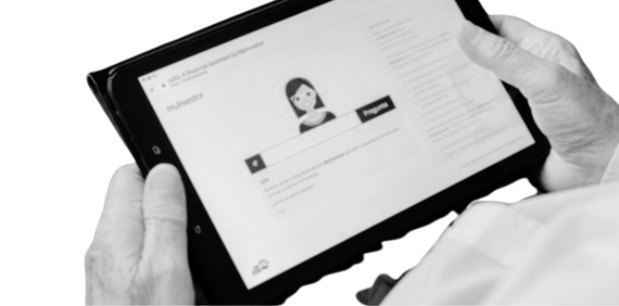 Manos sujetando una Tablet en cuya pantalla se ve la web de Myinvestor con la asesora virtual Julia